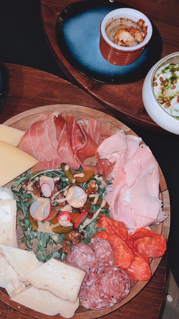 A delicious charcuterie board featuring various meats, cheeses, and pickles, ideal for gourmet gatherings.